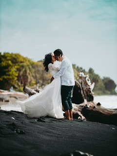 man and woman kissing on black asphalt road during daytime