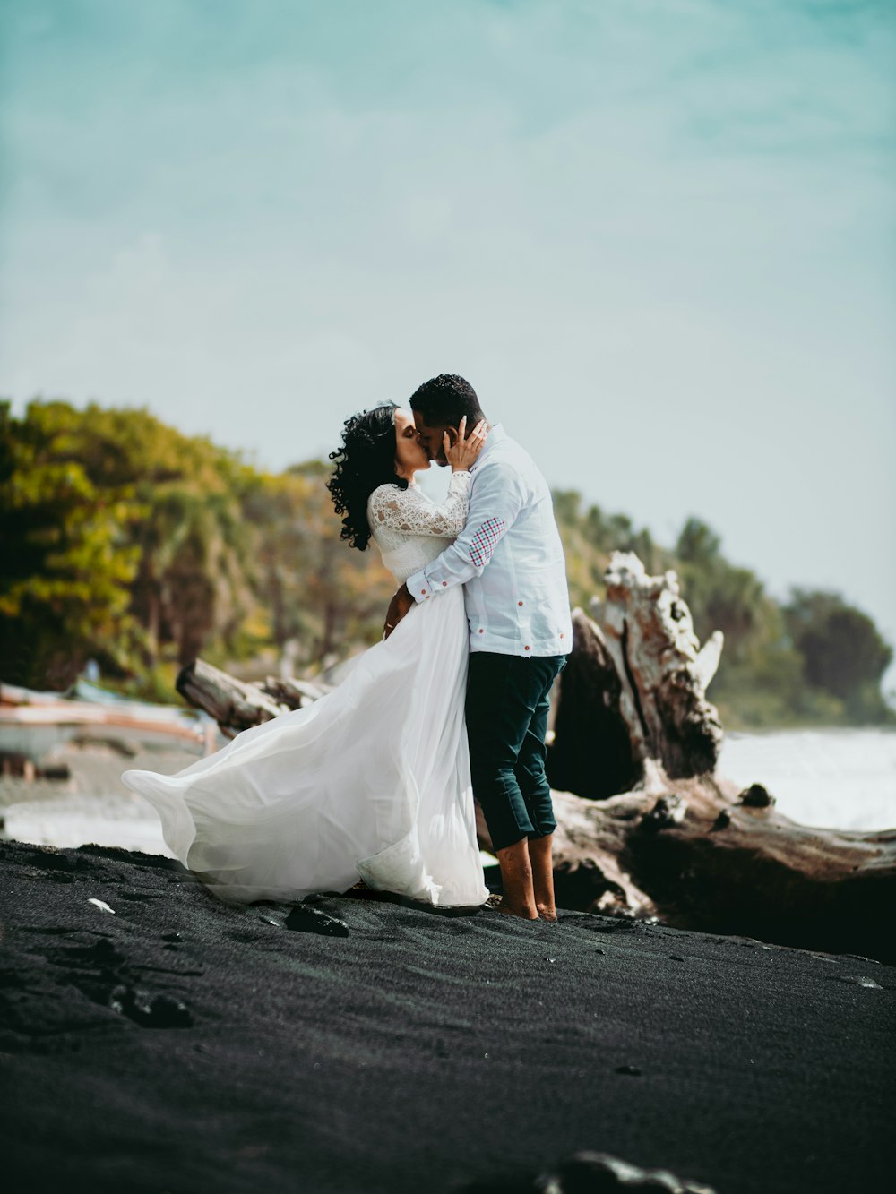 man and woman kissing on black asphalt road during daytime