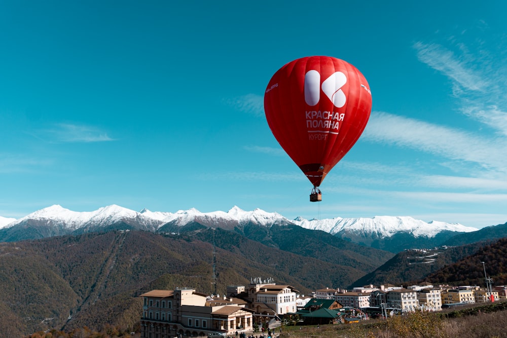 a red hot air balloon flying over a city