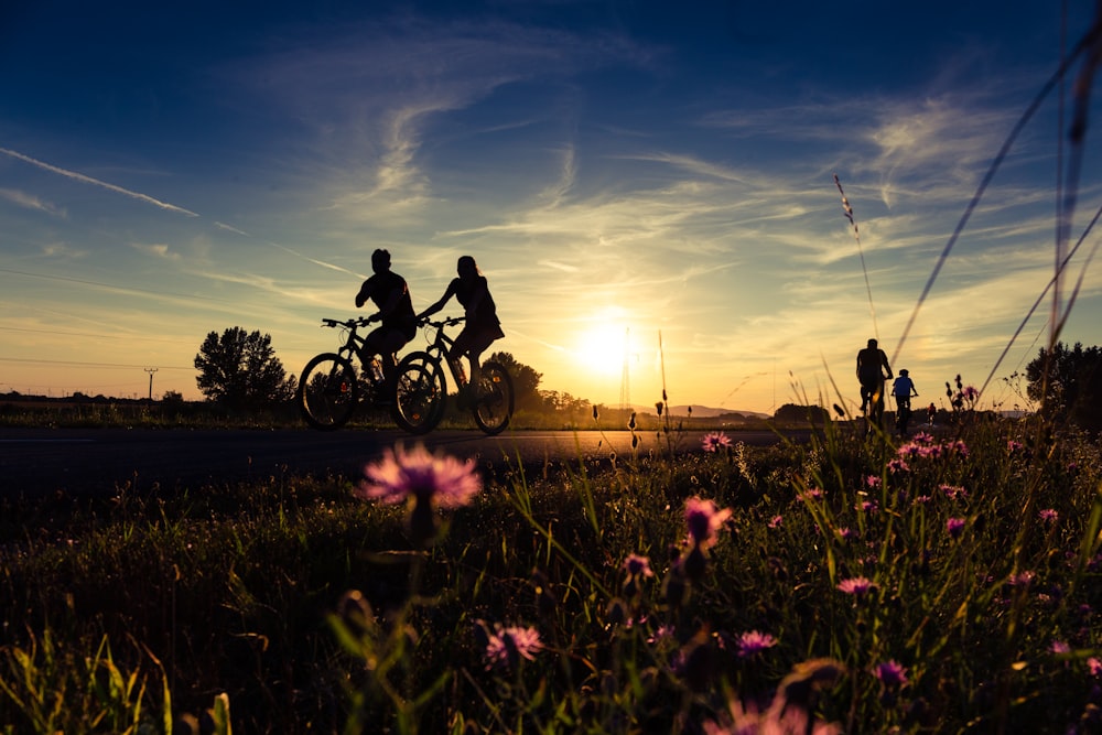 a couple of people riding bikes down a road