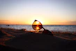 Sunglasses displayed on a sandy beach background with sunlight reflections