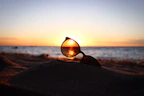 Sunglasses displayed on a sandy beach background with sunlight reflections