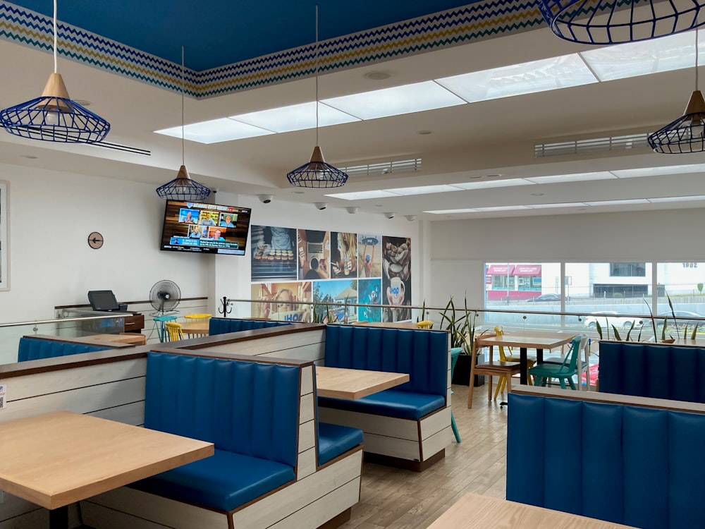 a restaurant with blue booths and wooden tables