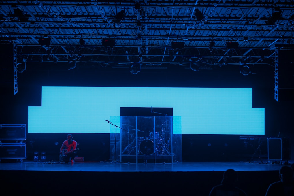 man in red shirt standing on white metal ladder