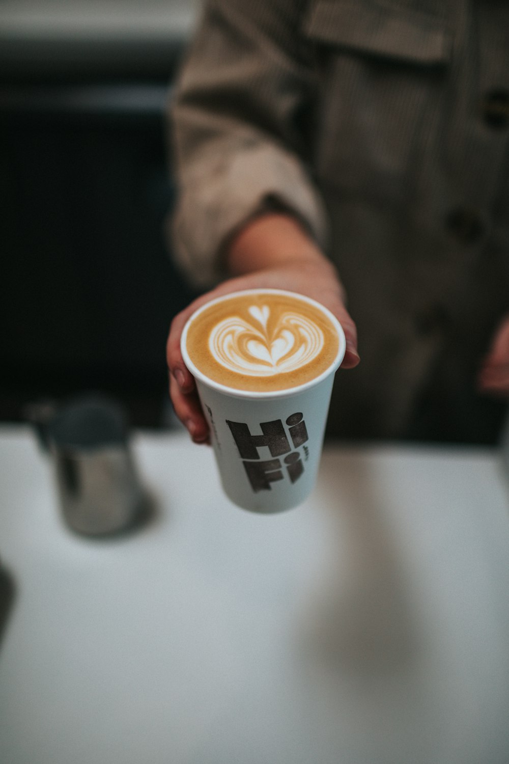 white and brown coffee cup