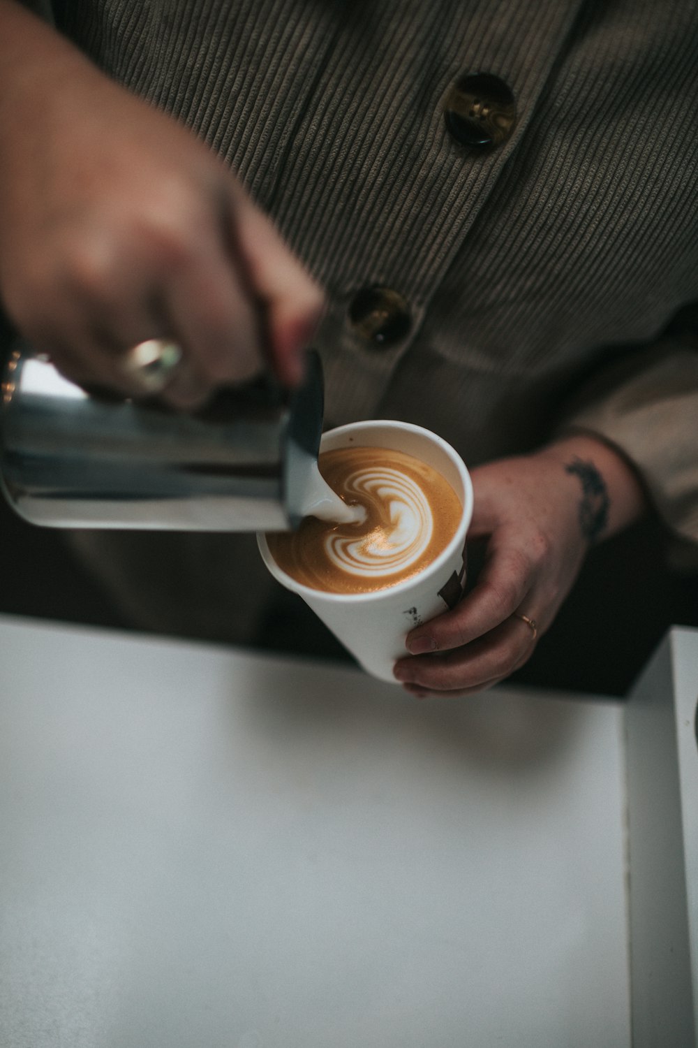 person holding white ceramic mug with coffee