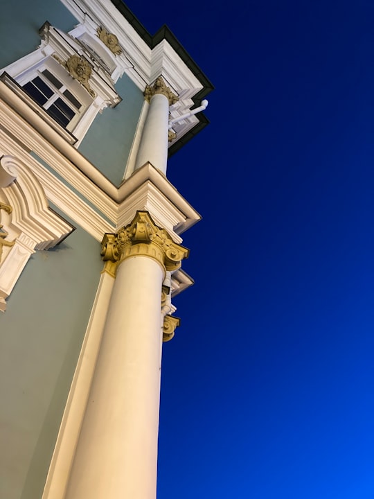 white concrete building under blue sky during daytime in State Hermitage Russia