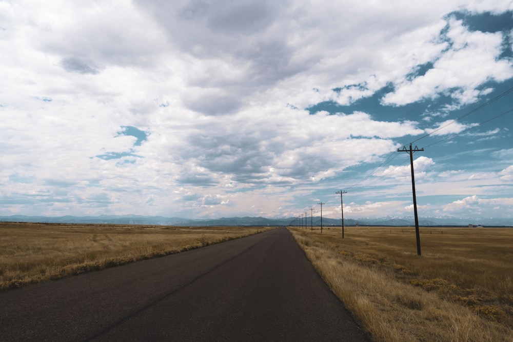 gray asphalt road under cloudy sky during daytime