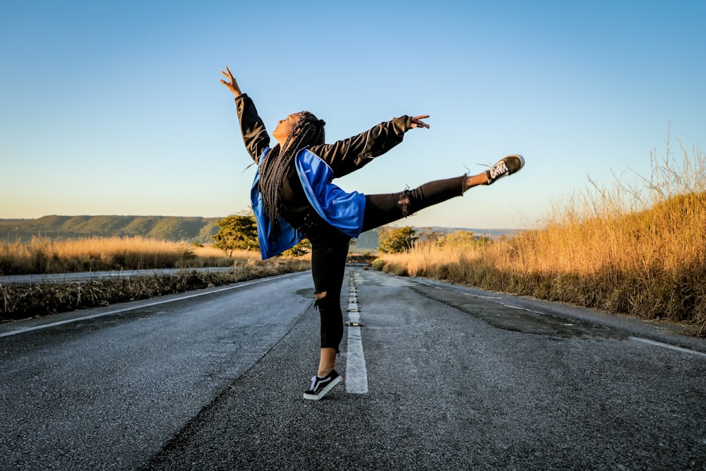 man in black jacket and blue pants running on road during daytime