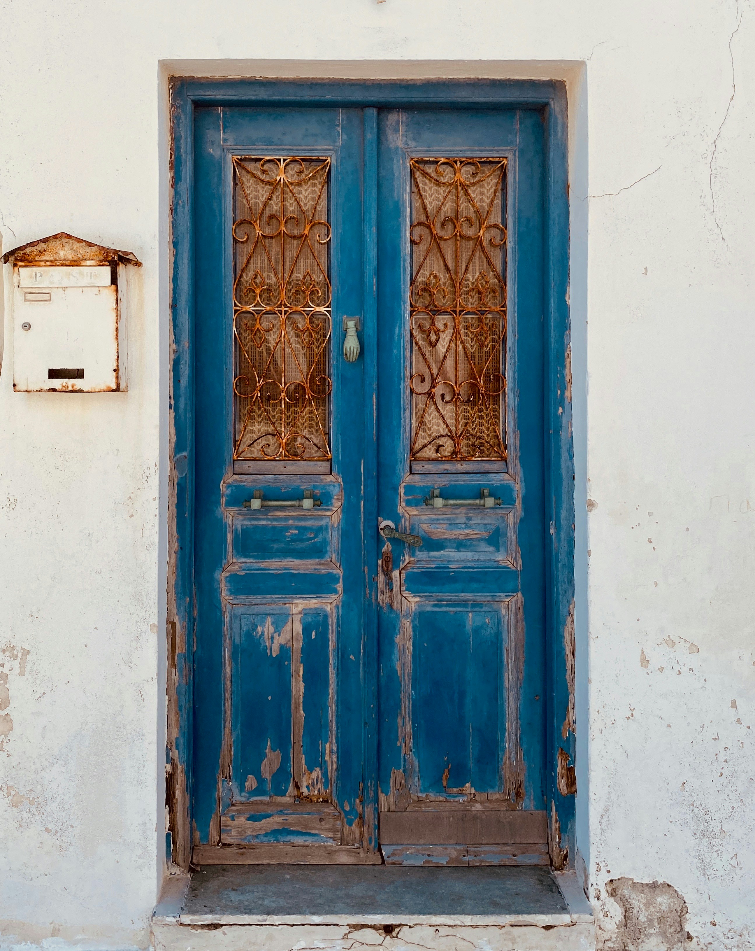 blue wooden door on white concrete wall