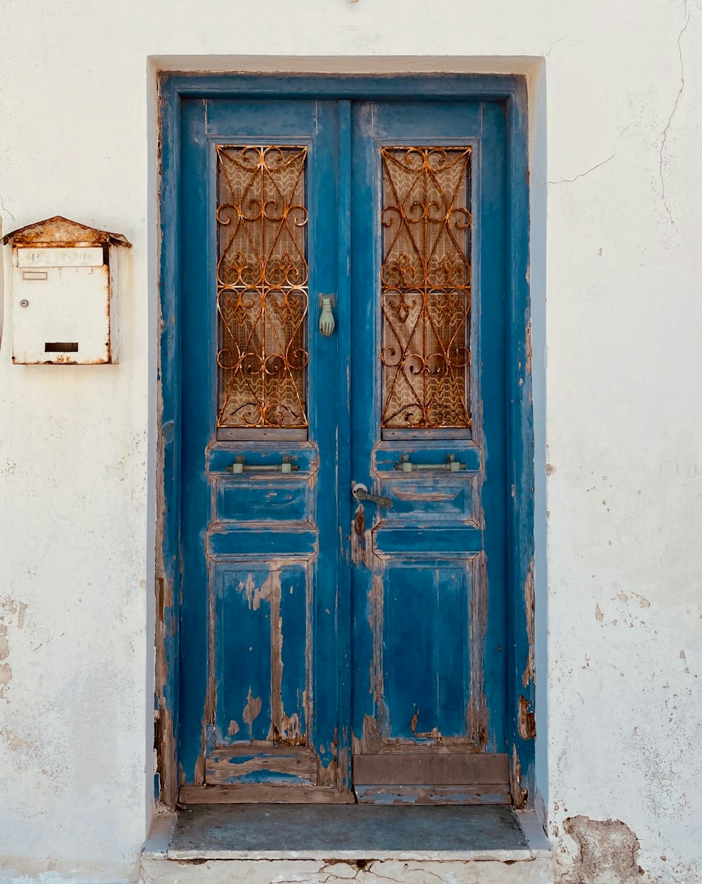 blue wooden door on white concrete wall