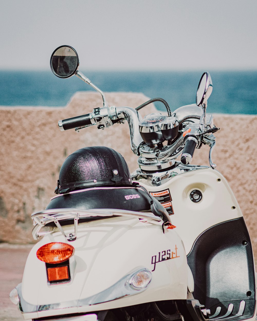 white and black motorcycle with orange plastic cup on top