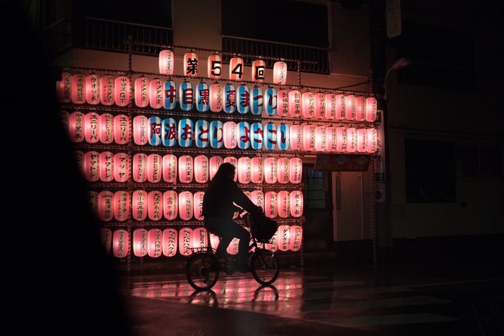 man in black jacket riding bicycle near blue and white plastic bottles