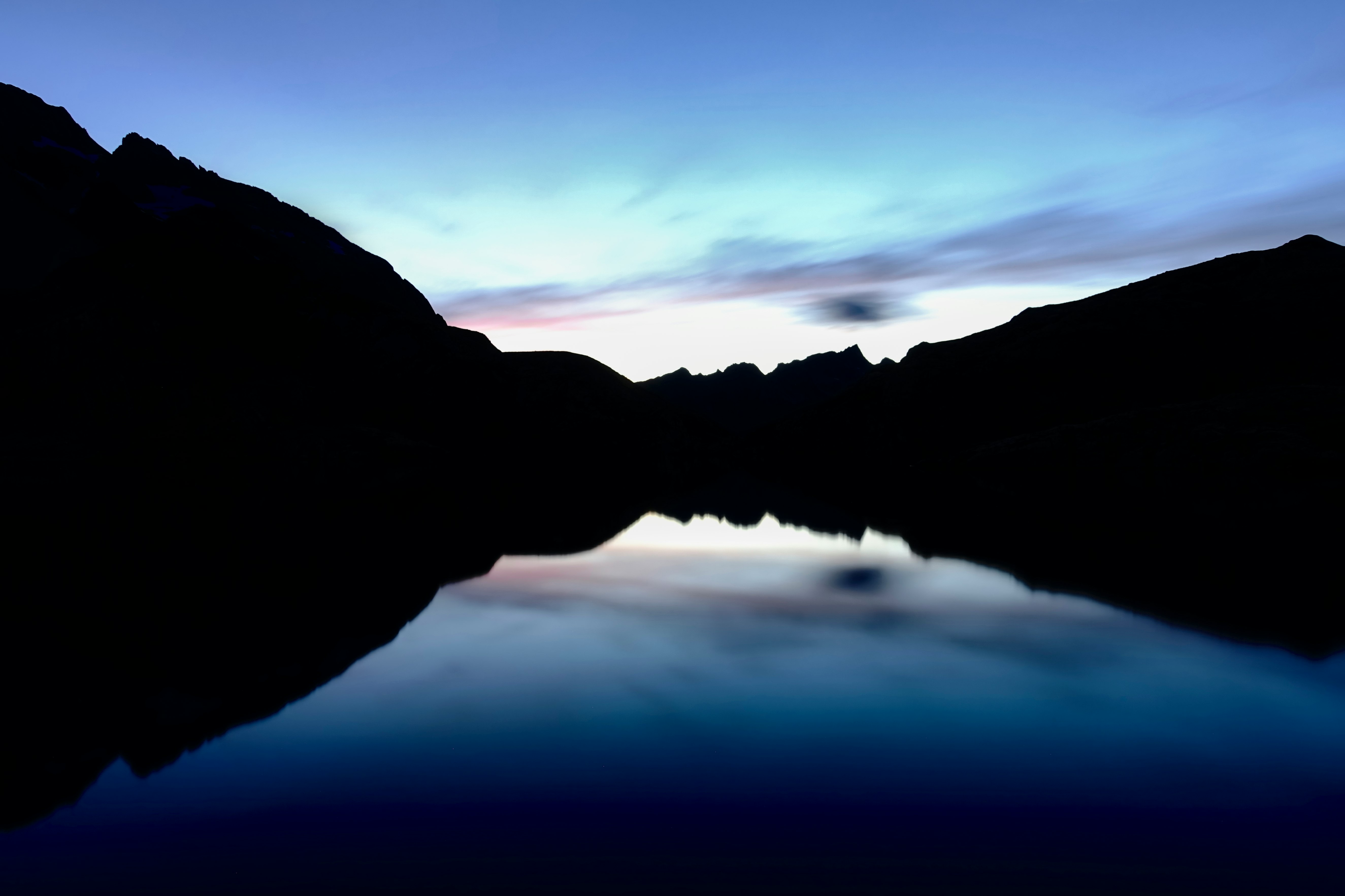 silhouette of mountain near body of water during night time
