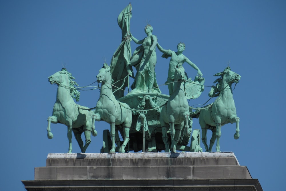 Gente montando estatua de caballo durante el día