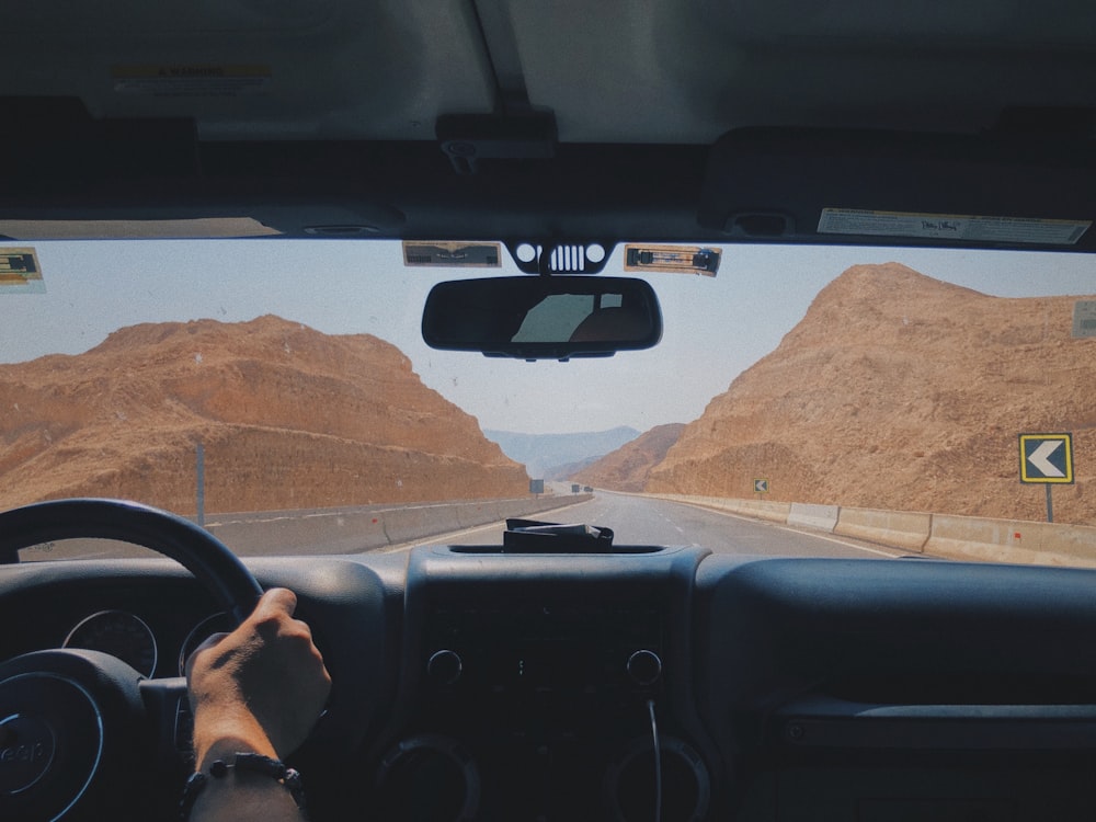 person driving car on desert during daytime