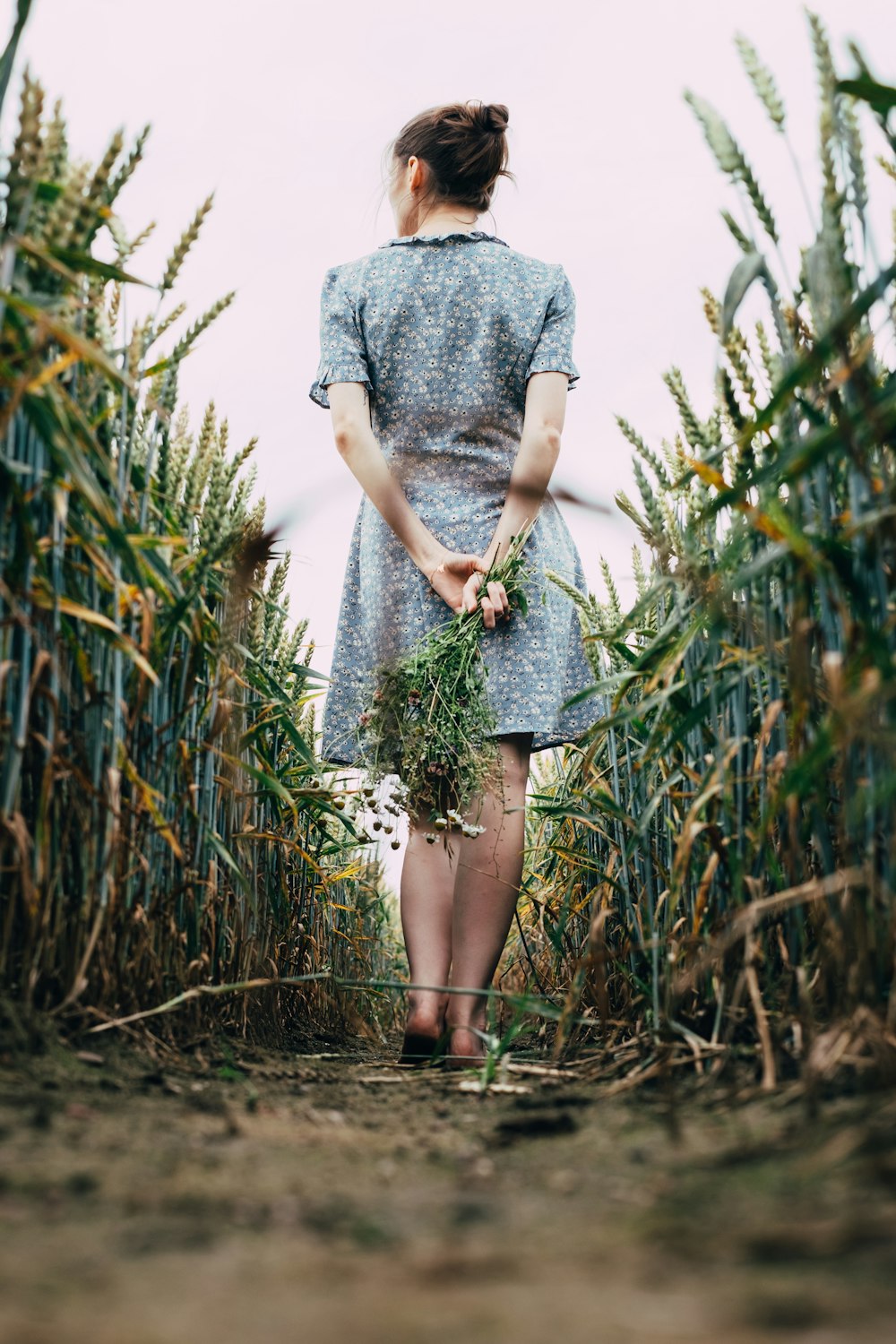 woman in gray dress standing on green grass field during daytime