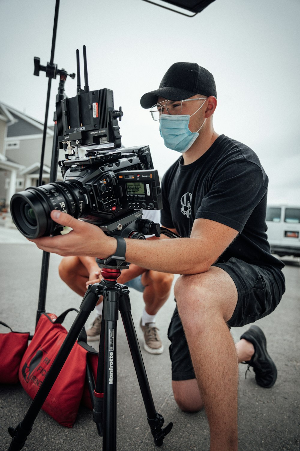 man in black crew neck t-shirt and black shorts holding black dslr camera