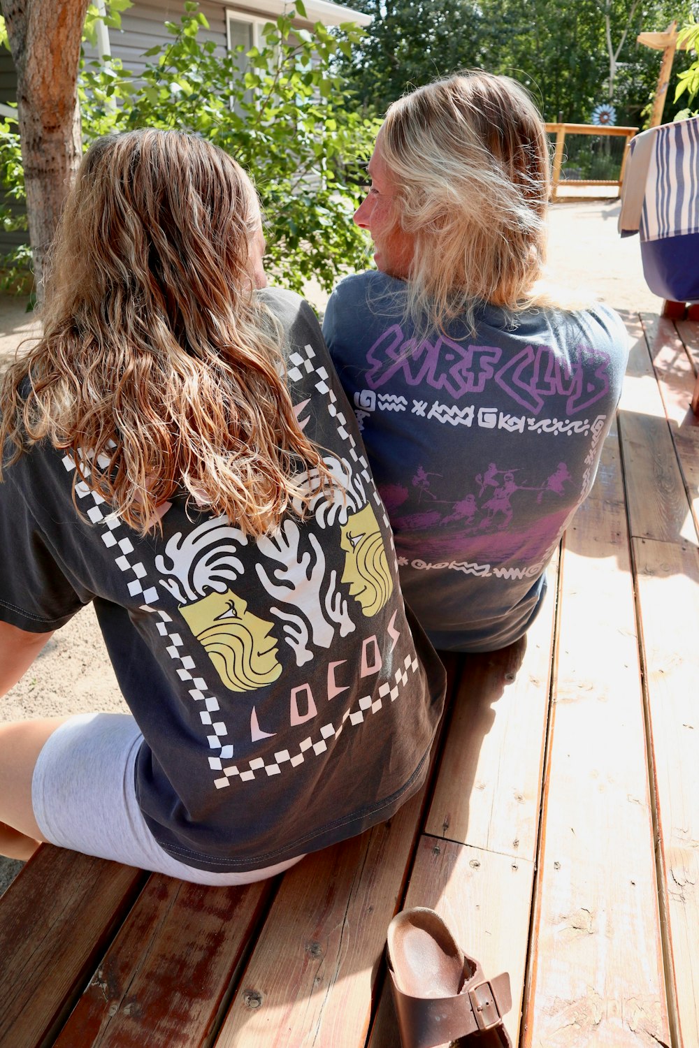 woman in black t-shirt sitting on brown wooden bench during daytime