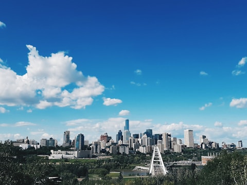 city skyline under blue and white sunny cloudy sky during daytime