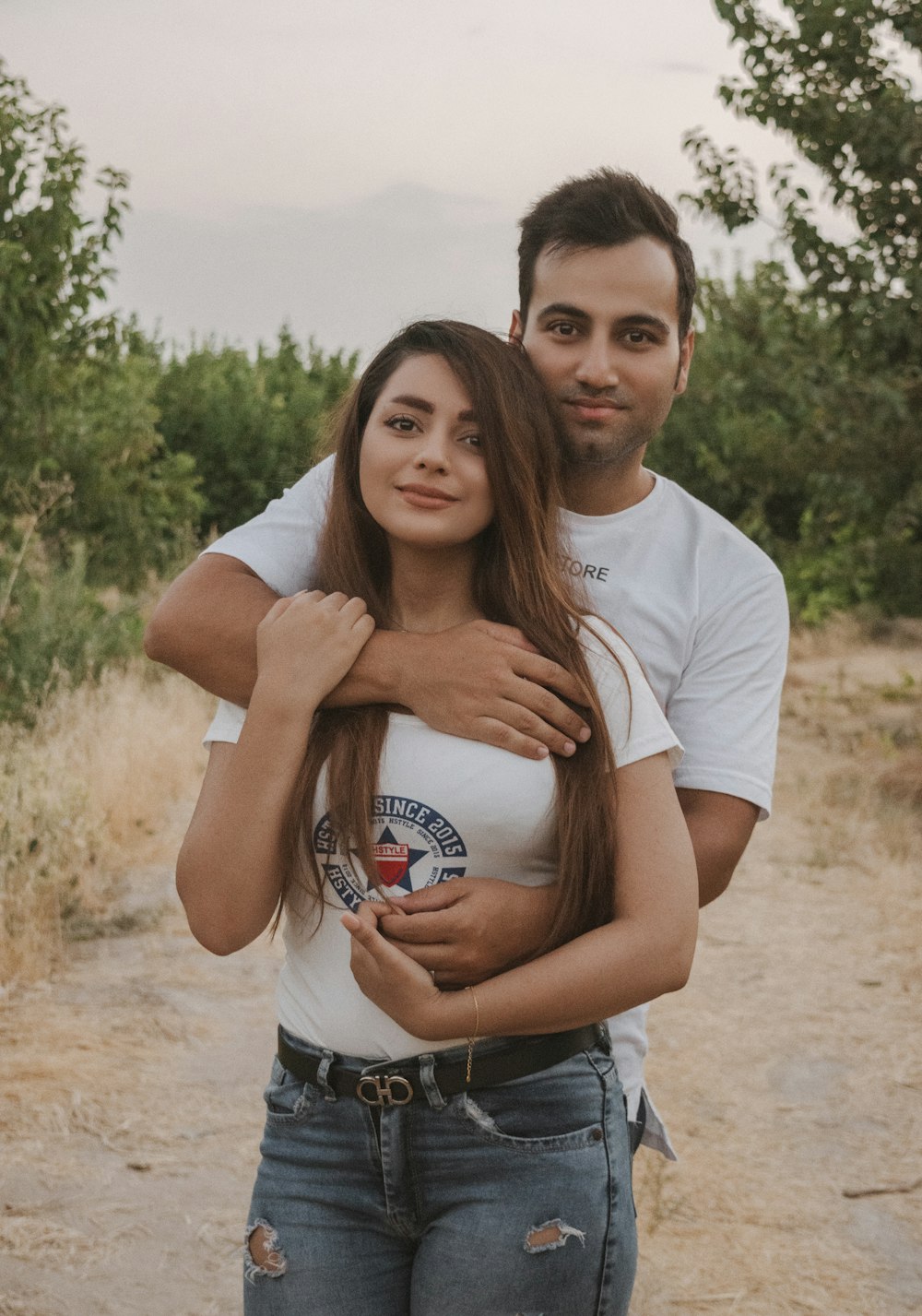 man in white crew neck t-shirt hugging woman in white t-shirt