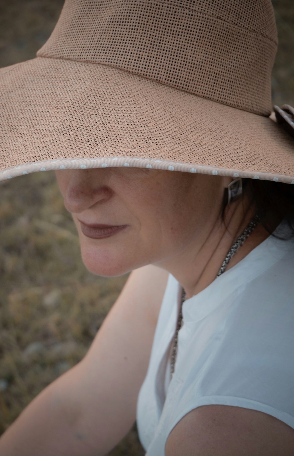 woman in white tank top wearing brown fedora hat