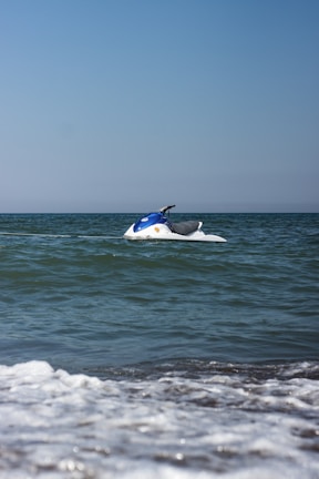 A jetski skimming over clear blue water near Browns Bay on a sunny day.