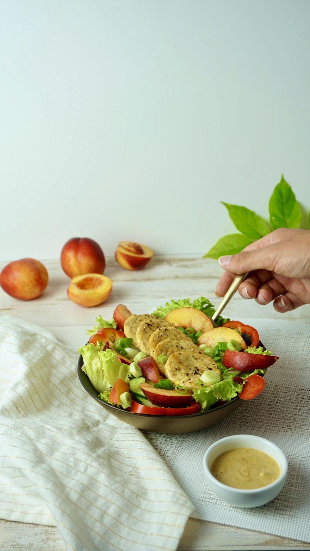 person holding stainless steel spoon with cooked food on white ceramic bowl