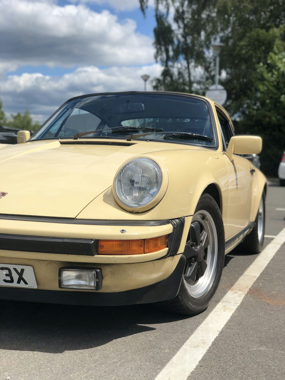 Porsche 911 jaune sur la route pendant la journée