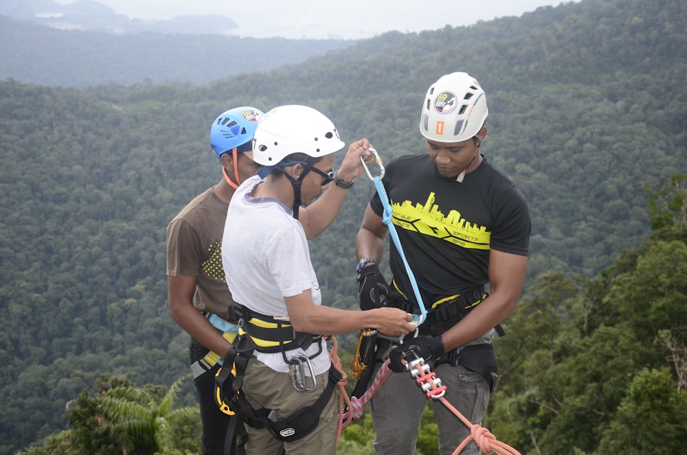 2 men in blue crew neck t-shirt holding sticks