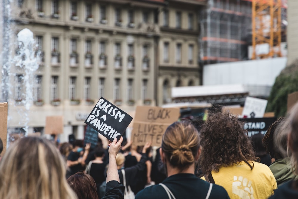 Menschen, die tagsüber schwarze und weiße Schilder halten