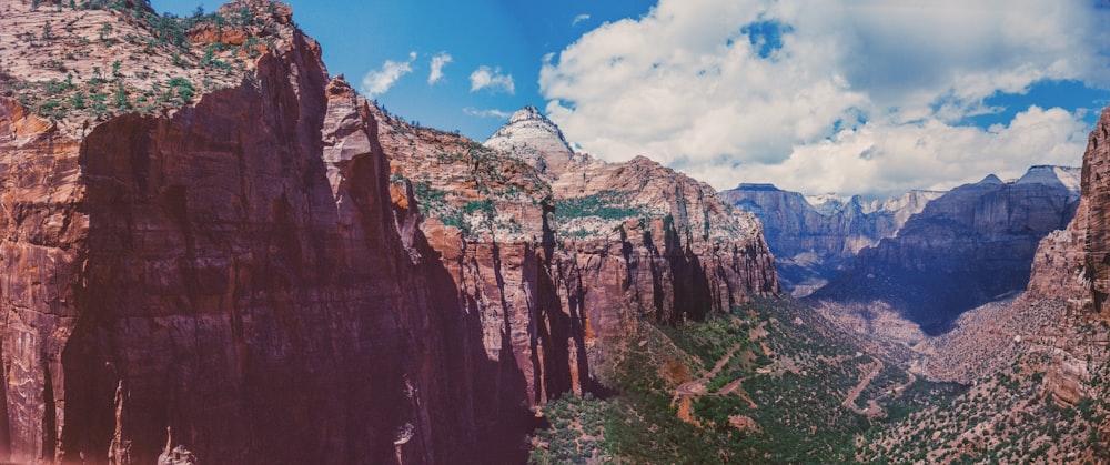 brown rocky mountain under blue sky and white clouds during daytime