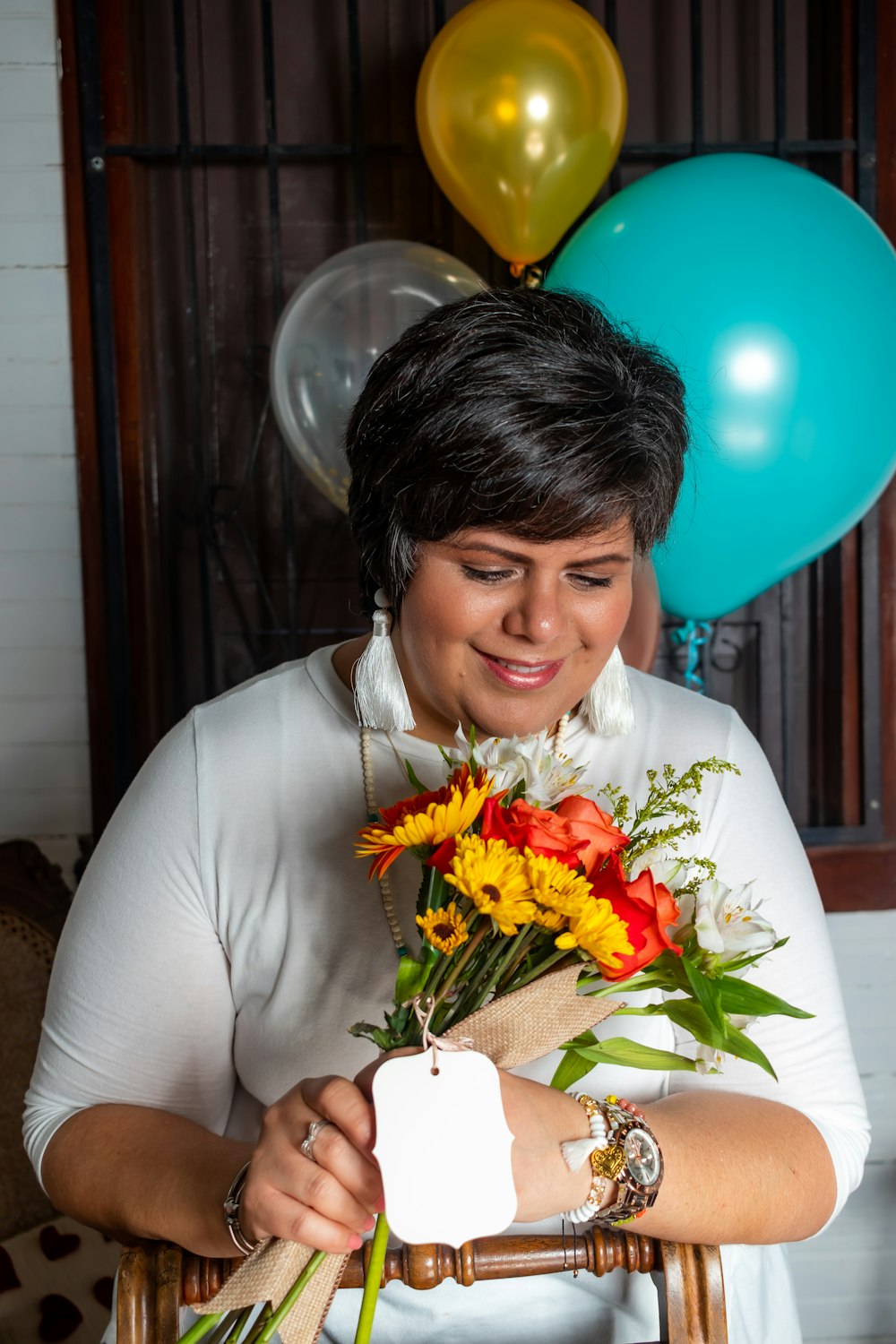 woman in white long sleeve shirt holding bouquet of flowers