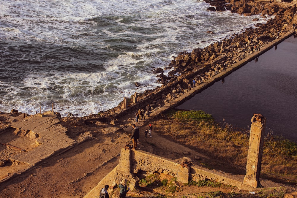 people walking on brown concrete bridge near body of water during daytime