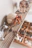 A cozy shelf displaying various handmade ceramic animal figures in warm lightcoral tones.