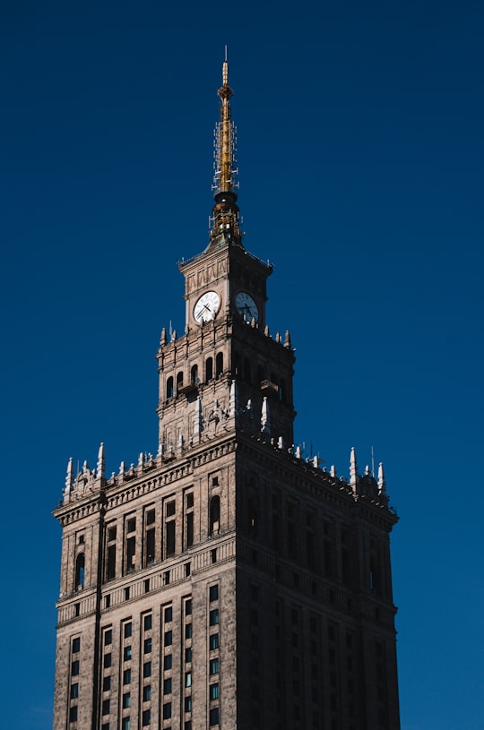 white concrete building under blue sky during daytime in Palace of Culture and Science Poland
