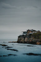 A luxurious beach house with large windows overlooking the ocean.