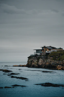 A luxurious beach house with large windows overlooking the ocean.