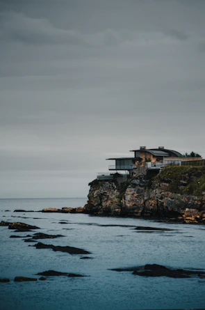 A luxurious beach house with large windows overlooking the ocean.