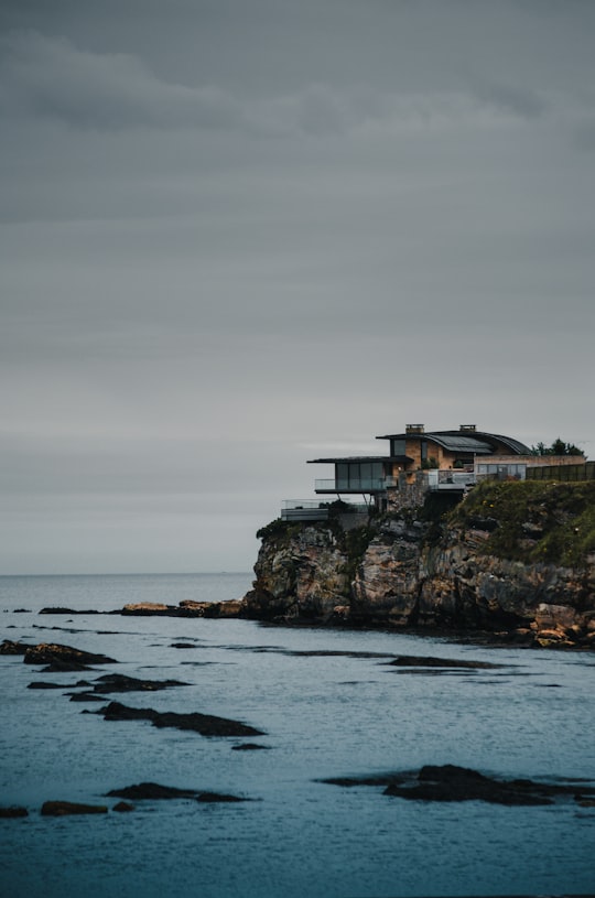 white and brown house on top of the hill by the sea under grey cloudy sky in St Andrews United Kingdom