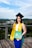 woman in yellow academic dress and black academic hat standing on top of a building during