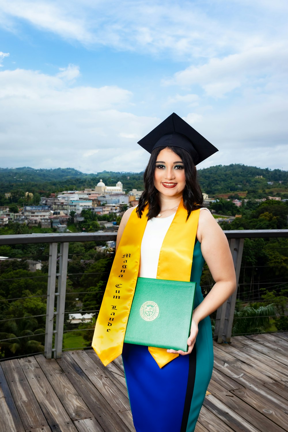 woman in yellow academic dress and black academic hat standing on top of a building during