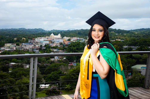 A proud graduate holding a government-recognized certification, smiling against a backdrop of the national flag colors.