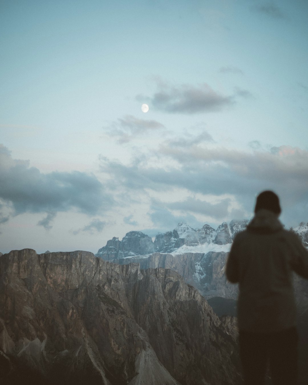 man in black jacket standing on top of mountain during daytime