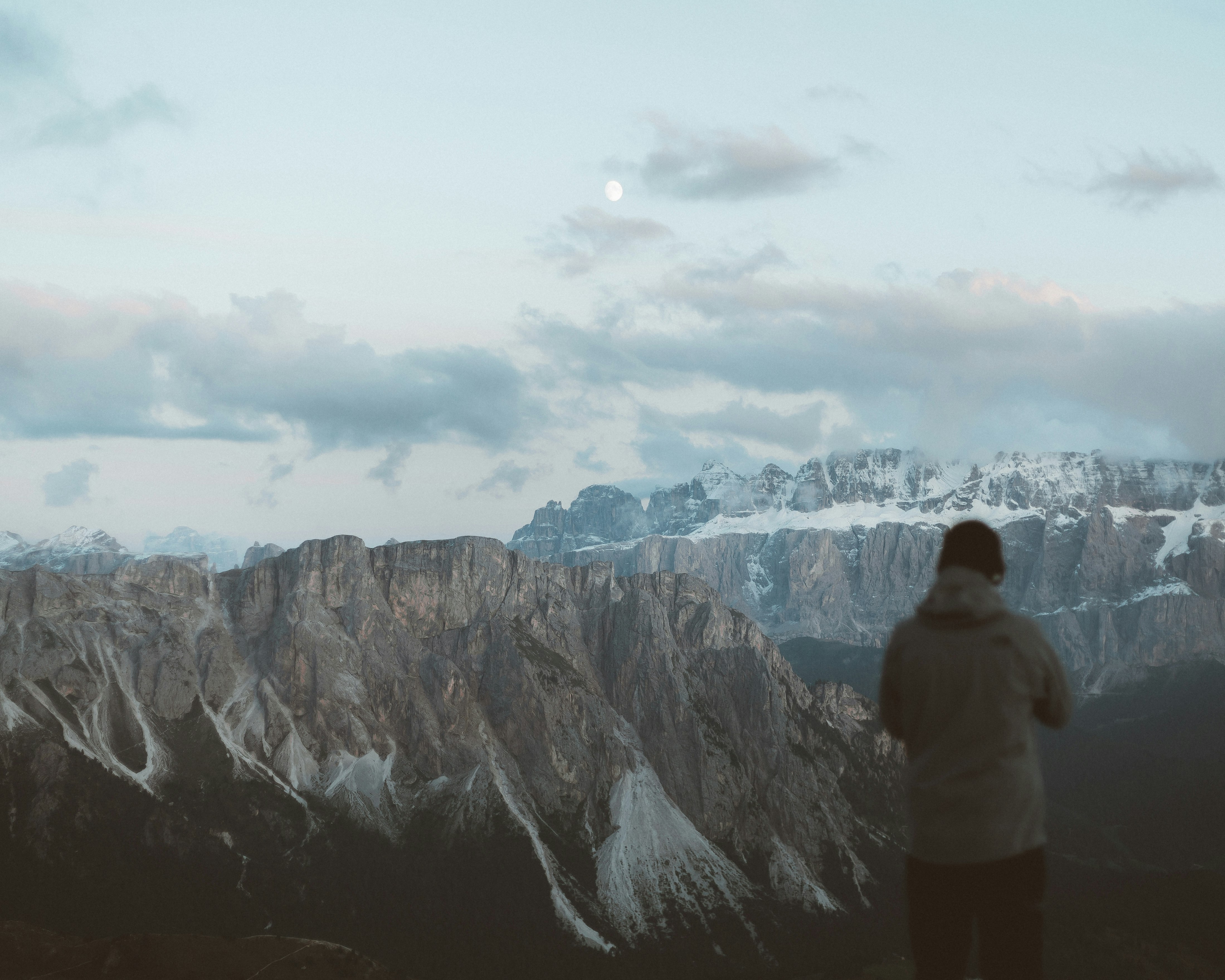 man in white jacket standing on top of mountain during daytime