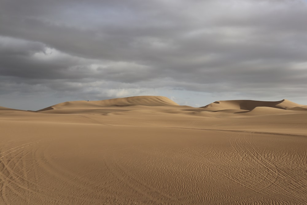 brown sand under white clouds during daytime