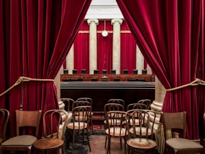 red curtain near brown wooden chairs