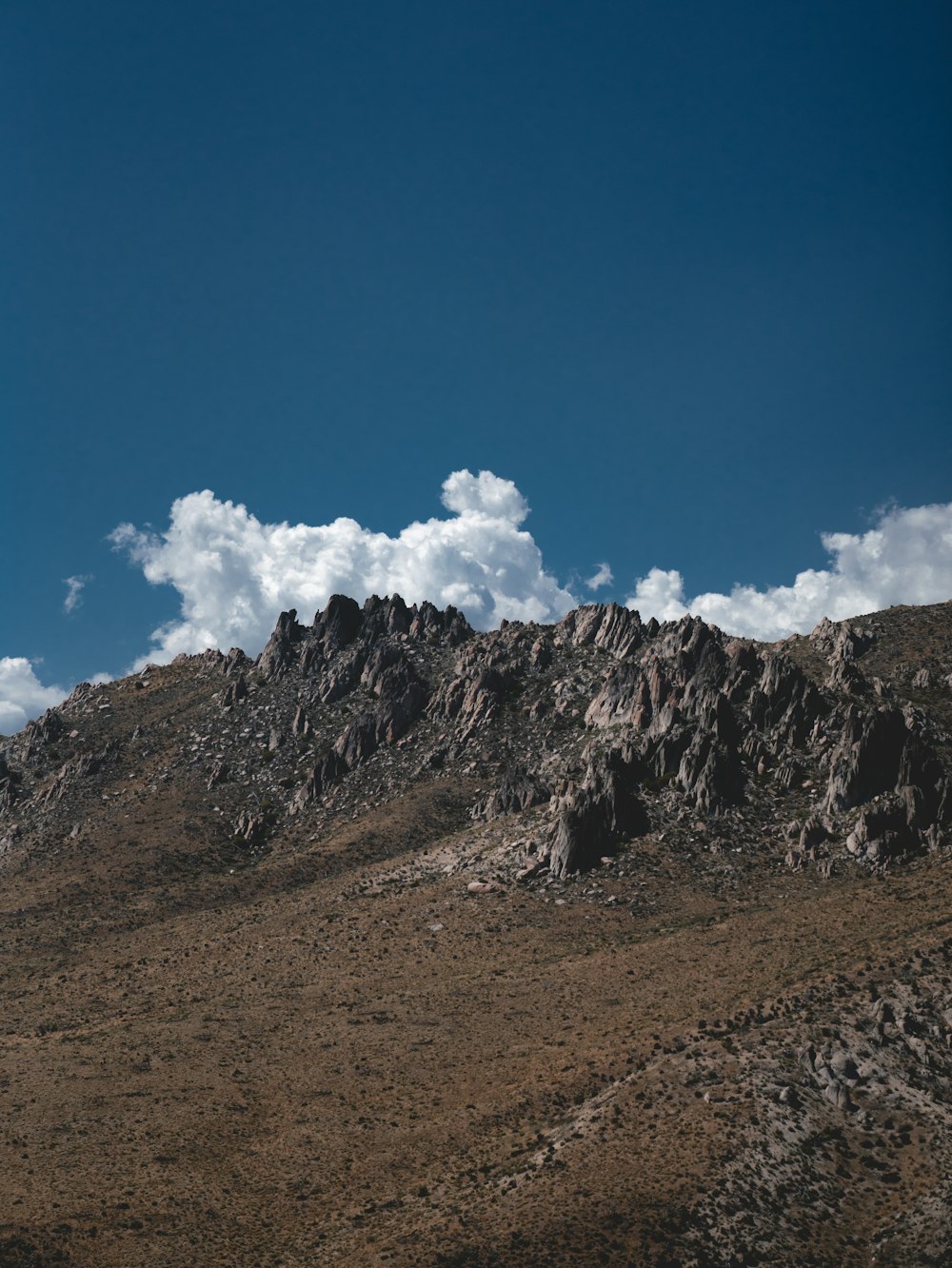 montanha marrom e cinza sob o céu azul durante o dia