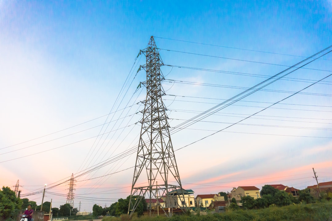 High-voltage power lines at sunset, electricity distribution station. High voltage electric transmission tower.