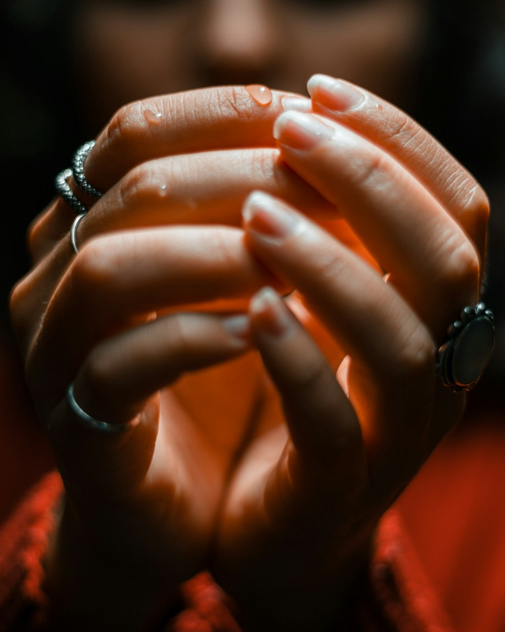 um close up de uma pessoa segurando as mãos juntas